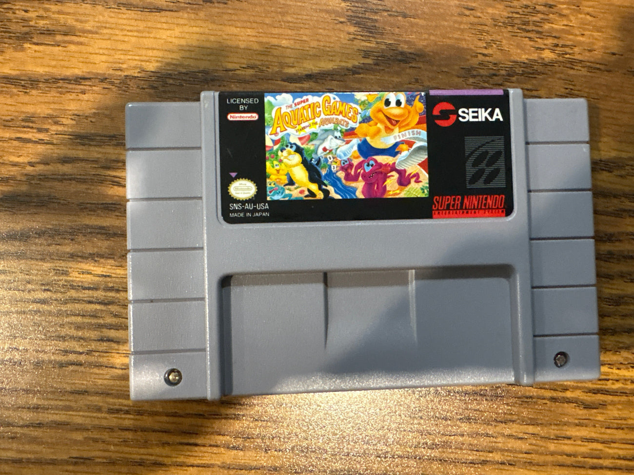 Super Nintendo Entertainment System game cartridge of The super aquatic games starring the aquabots 